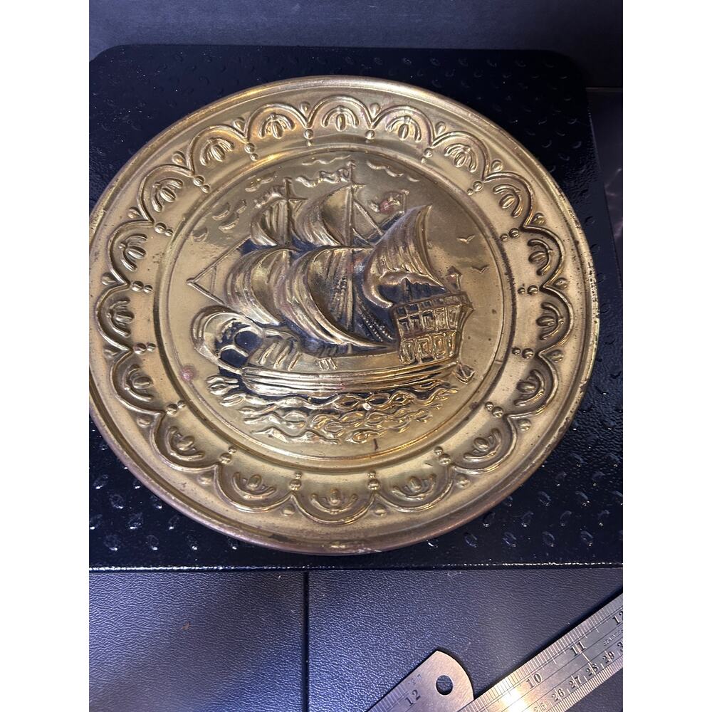 vintage embossed brass ship wall plate used for nautical-themed decor